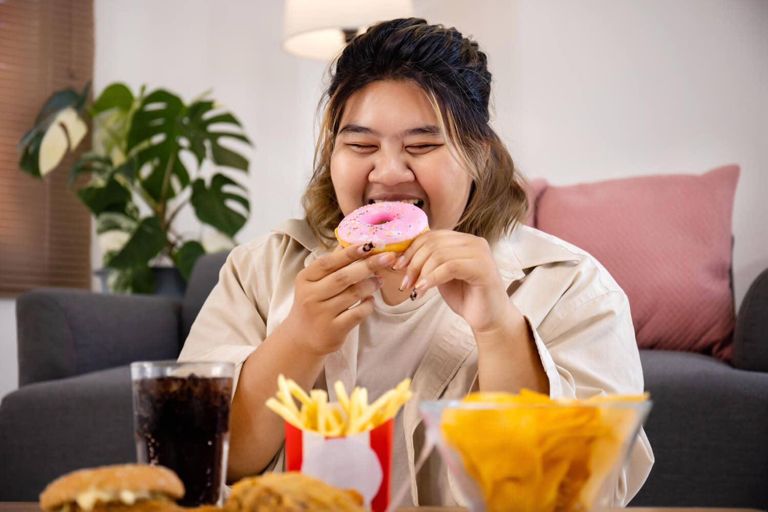 happy-asian-fat-woman-enjoy-eating-delicious-sweet-donut-fast-food-living-room